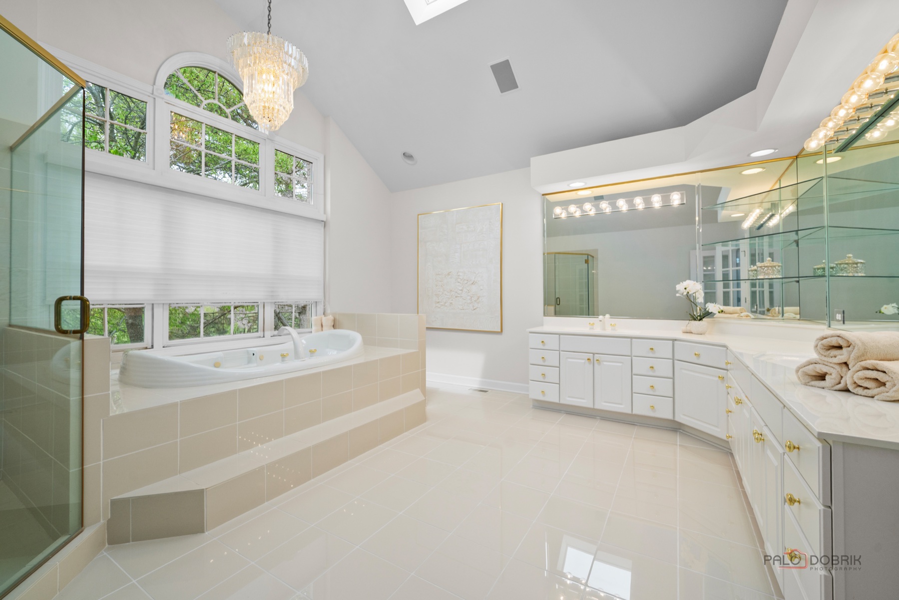 Bright bathroom remodel with tub, vanity, and glass shower