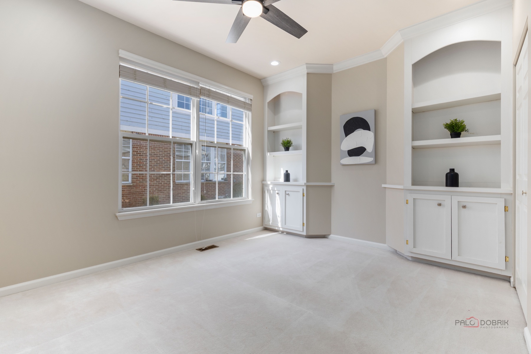 Clean painted room with white trim and built-in shelving